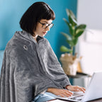 AI-generated image: woman wearing the heated poncho at a laptop